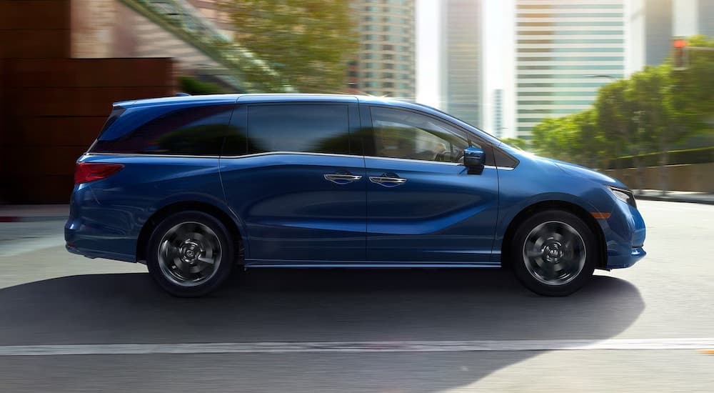 A blue 2025 Honda Odyssey is shown from the side.
