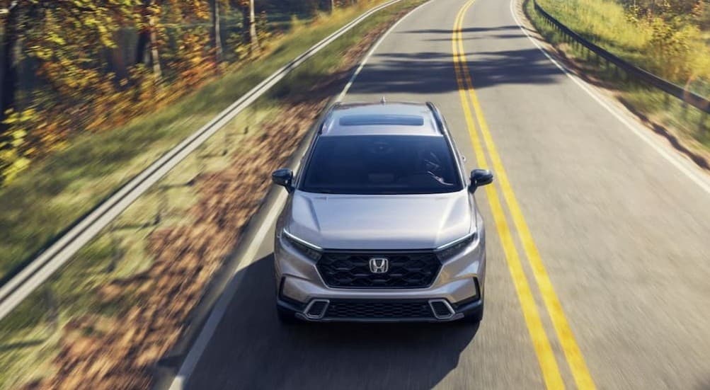 A silver v driving on a highway.