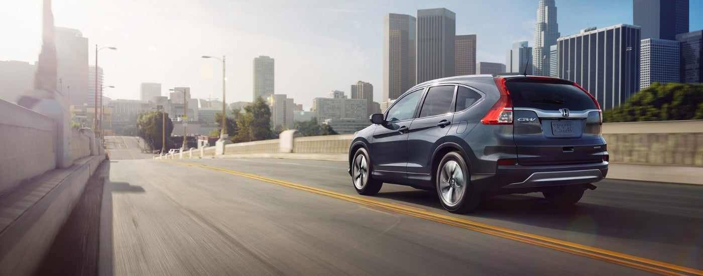 Blue 2015 Honda CR-V Touring driving on a city street