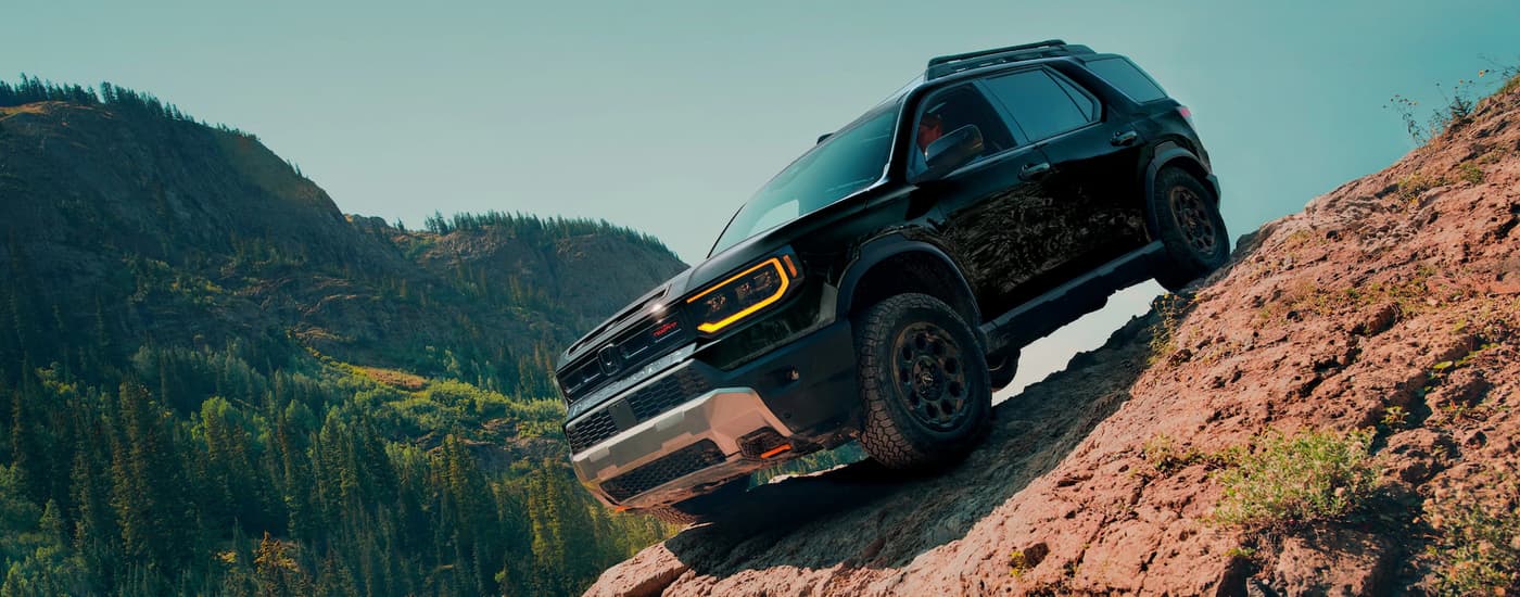 Black 2026 Honda Passport off-roading on a steep rocky trail