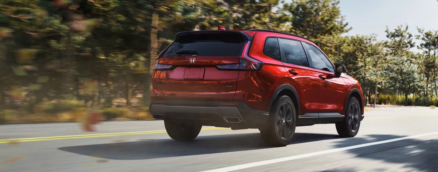 A red 2026 Honda CR-V driving on a highway.