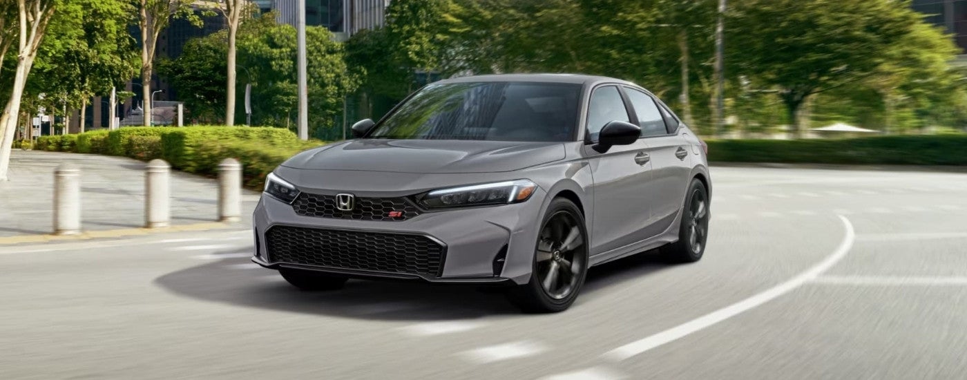 A grey 2025 Honda Civic Si is shown driving to a Honda dealer near Carmel.