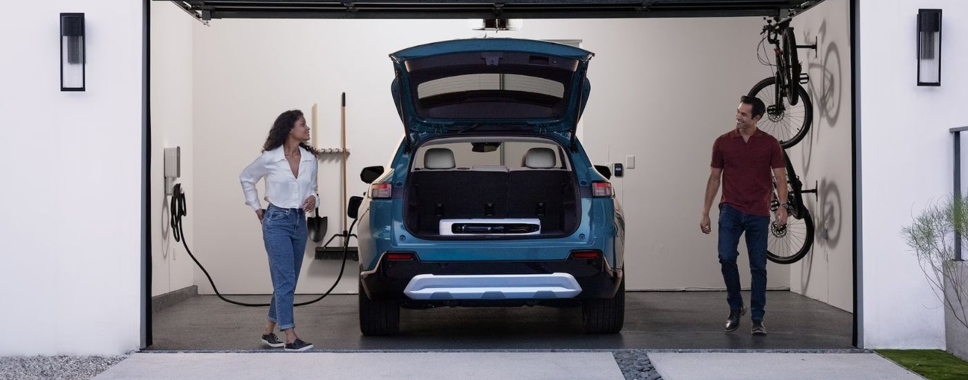 A blue 2024 Honda Prologue charing in a garge.