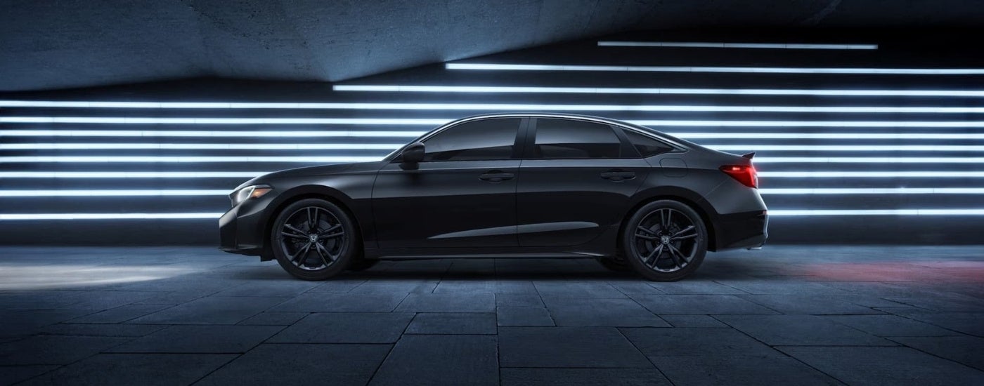 A black 2025 Honda Civic Si parked in a modern gallery.