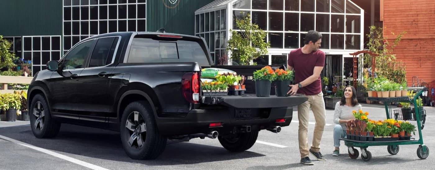 A black 2025 Honda Ridgeline parked near a greenery.